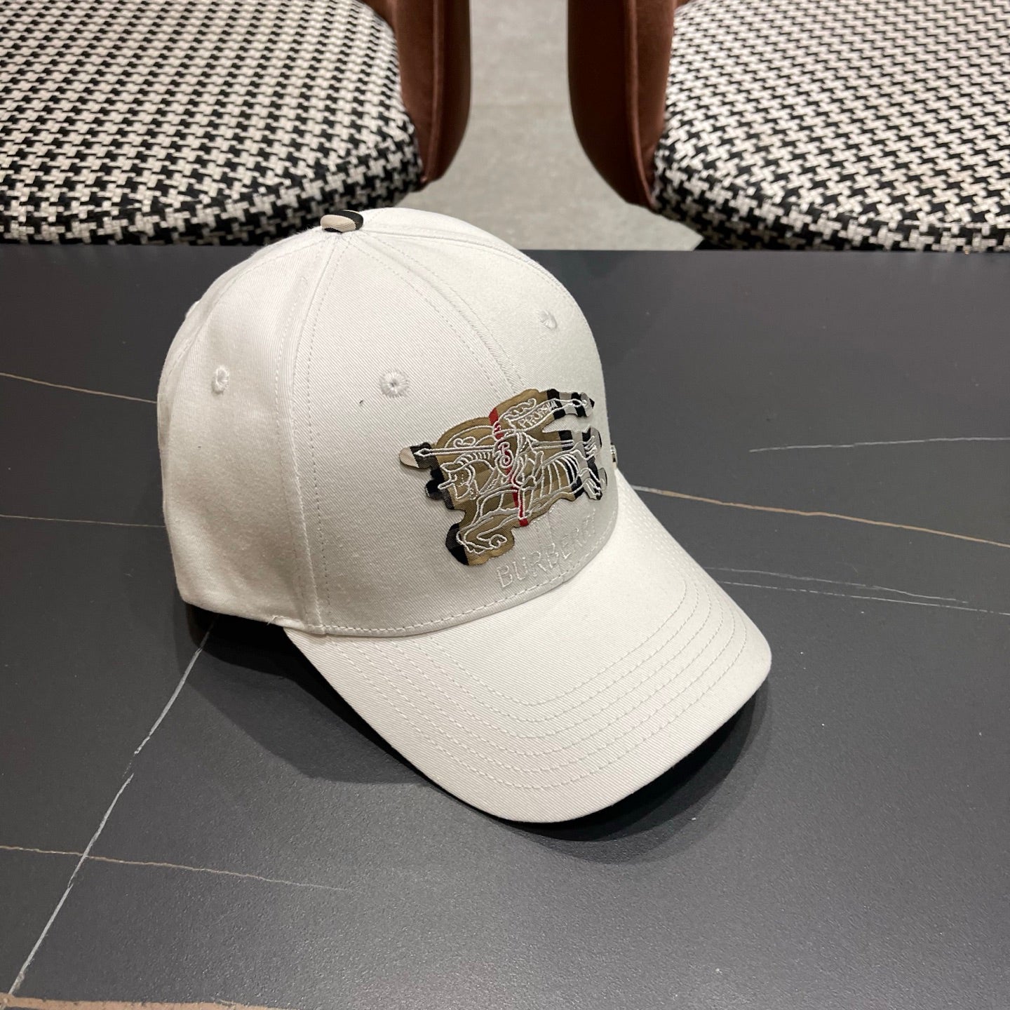 A white structured cotton baseball cap featuring an intricate equestrian embroidery patch on front.