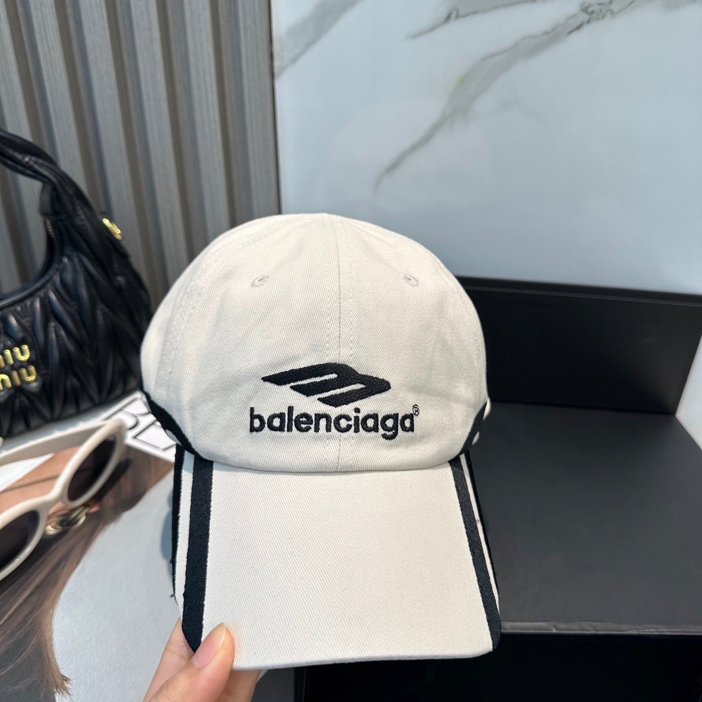 A premium white cotton baseball cap with black contrast detailing and an adjustable back strap.