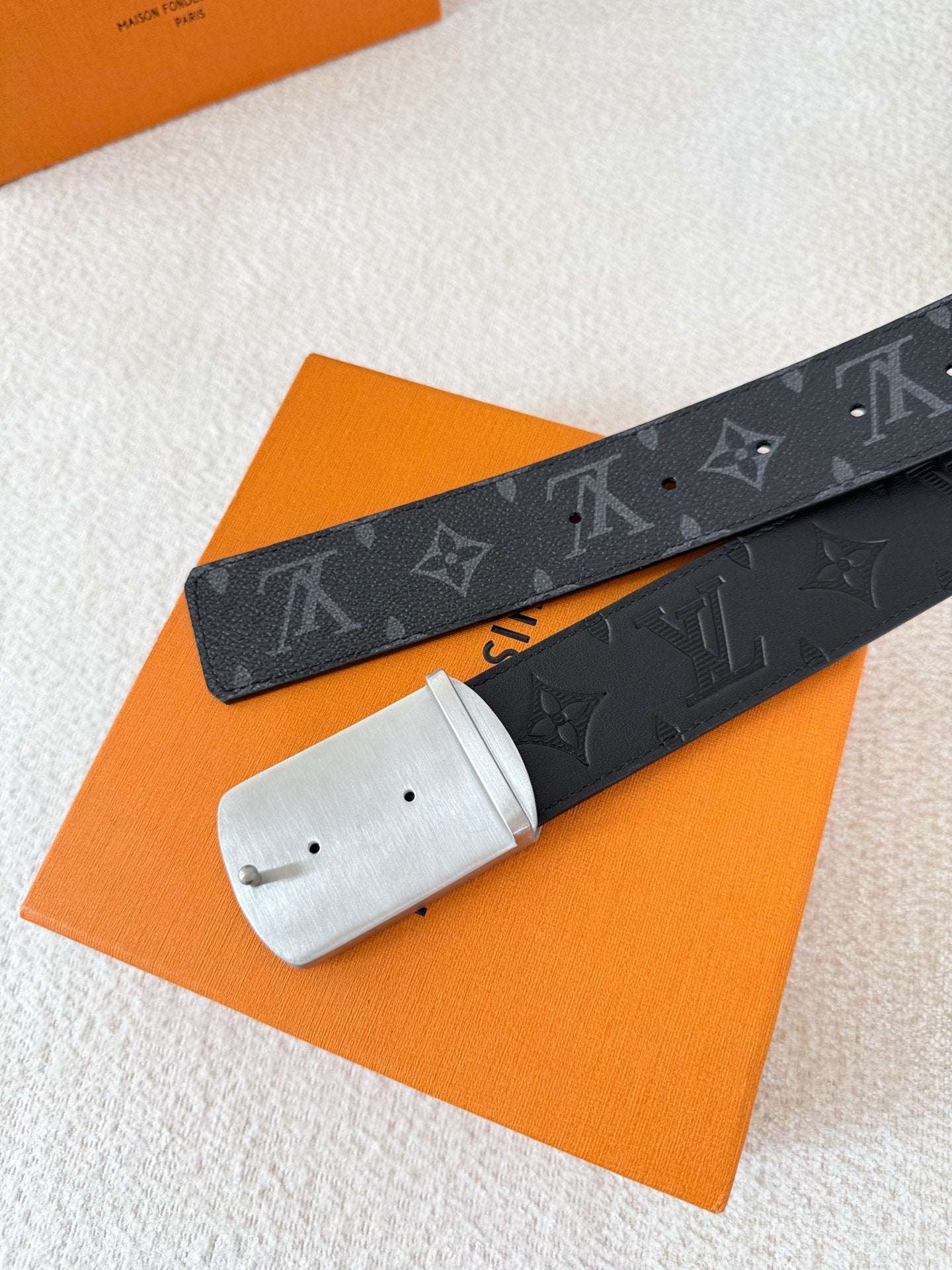 A black leather belt with monogram pattern and an intricate silver-tone buckle, 3.8cm wide.