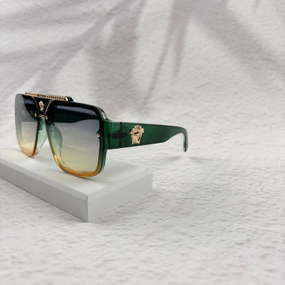 Oversized geometric sunglasses with green-to-yellow gradient lenses and gold metallic frame details.