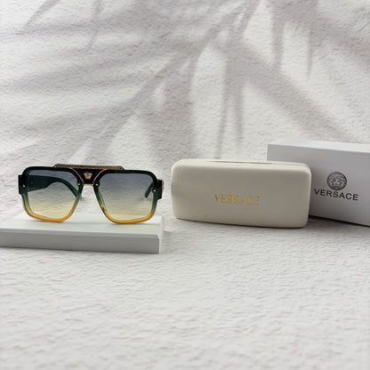 Oversized geometric sunglasses with green-to-yellow gradient lenses and gold metallic frame details.