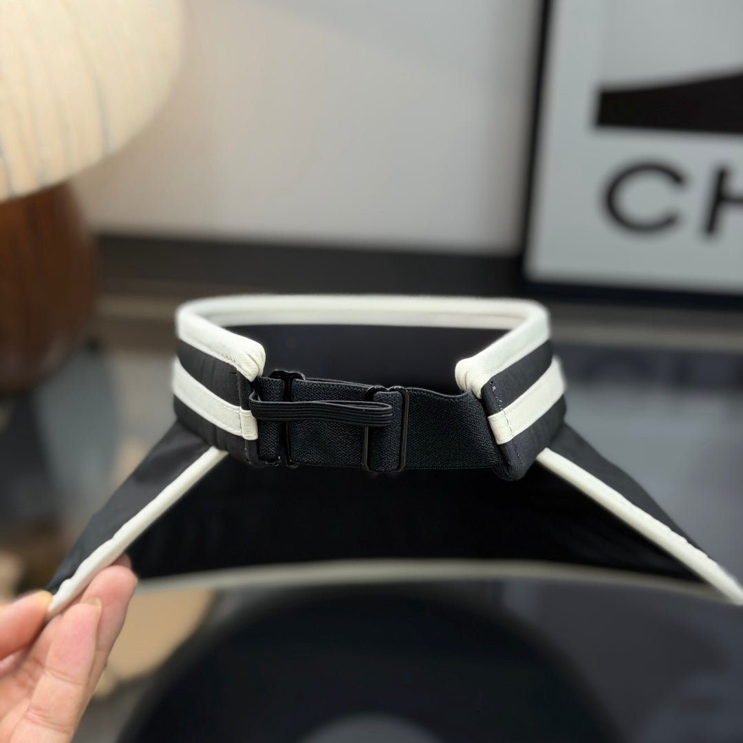 A black sun visor with white contrast trim, featuring an open-top design for breathability and sun p