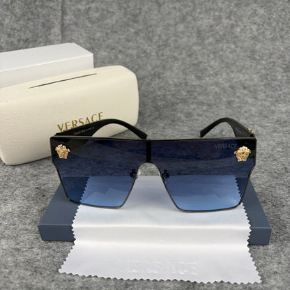 Oversized shield sunglasses with gradient blue lenses and gold metallic accents on the side arms.