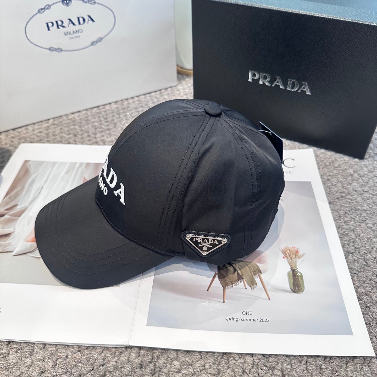 Black nylon baseball cap with white embroidered lettering and side metal logo plaque.