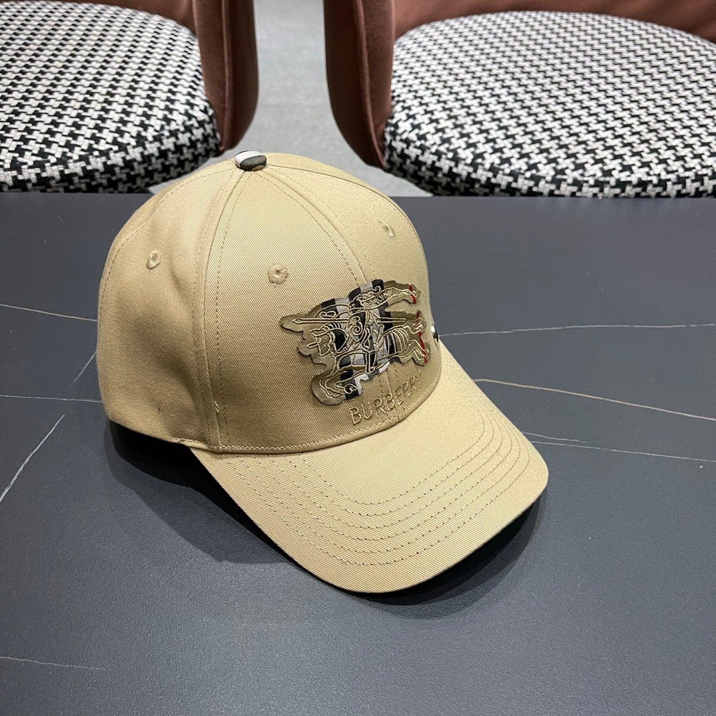 Khaki baseball cap with detailed embroidery on the front and an adjustable strap closure.