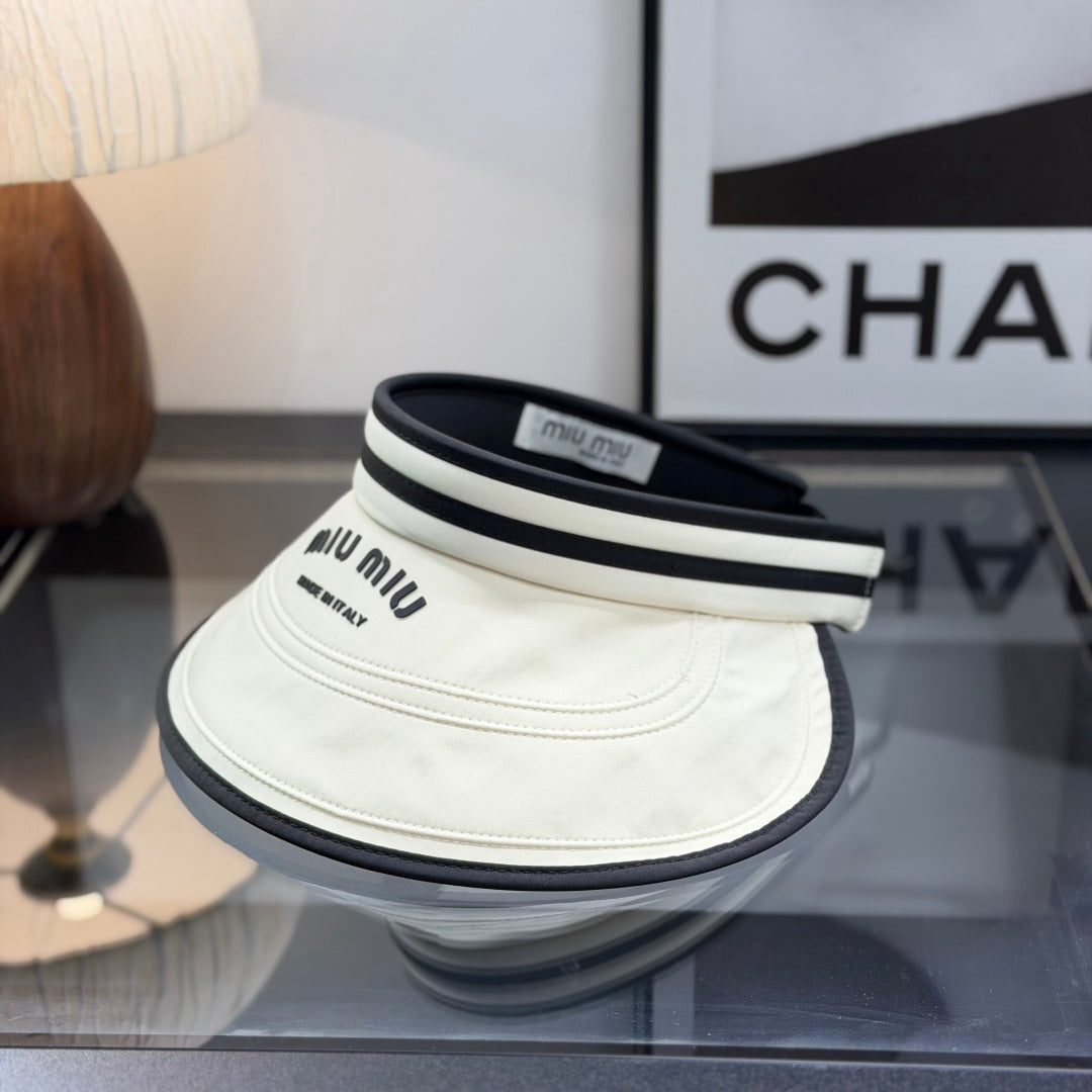 A stylish off-white open-top sports visor with black trim and embroidered text detailing.