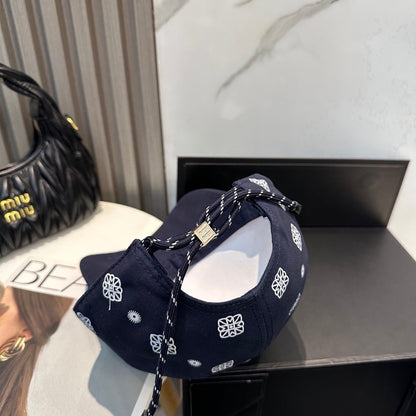 Navy blue baseball cap with white embroidered paisley patterns and an adjustable back strap.
