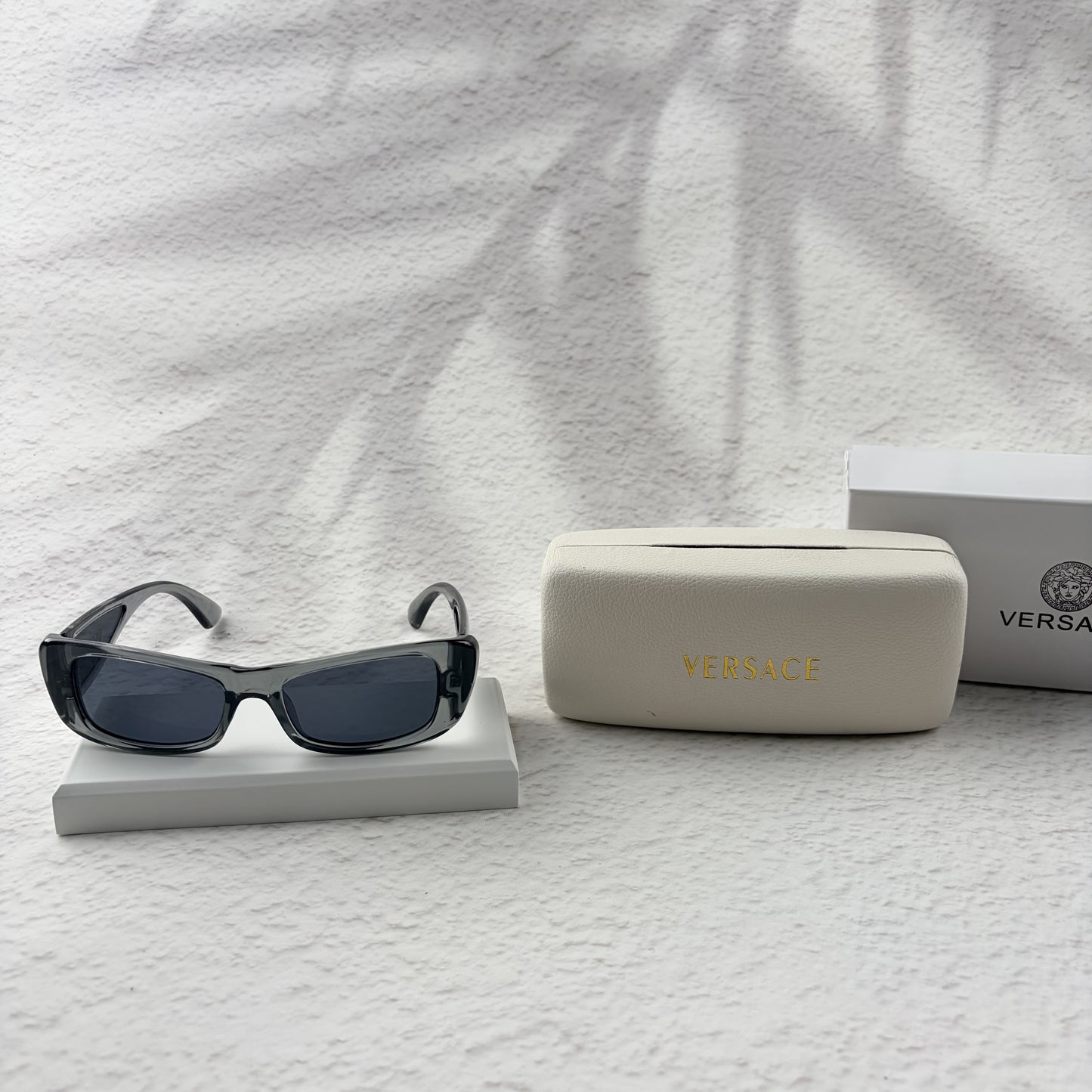 Modern rectangular sunglasses in translucent gray with dark tinted lenses, includes protective case.