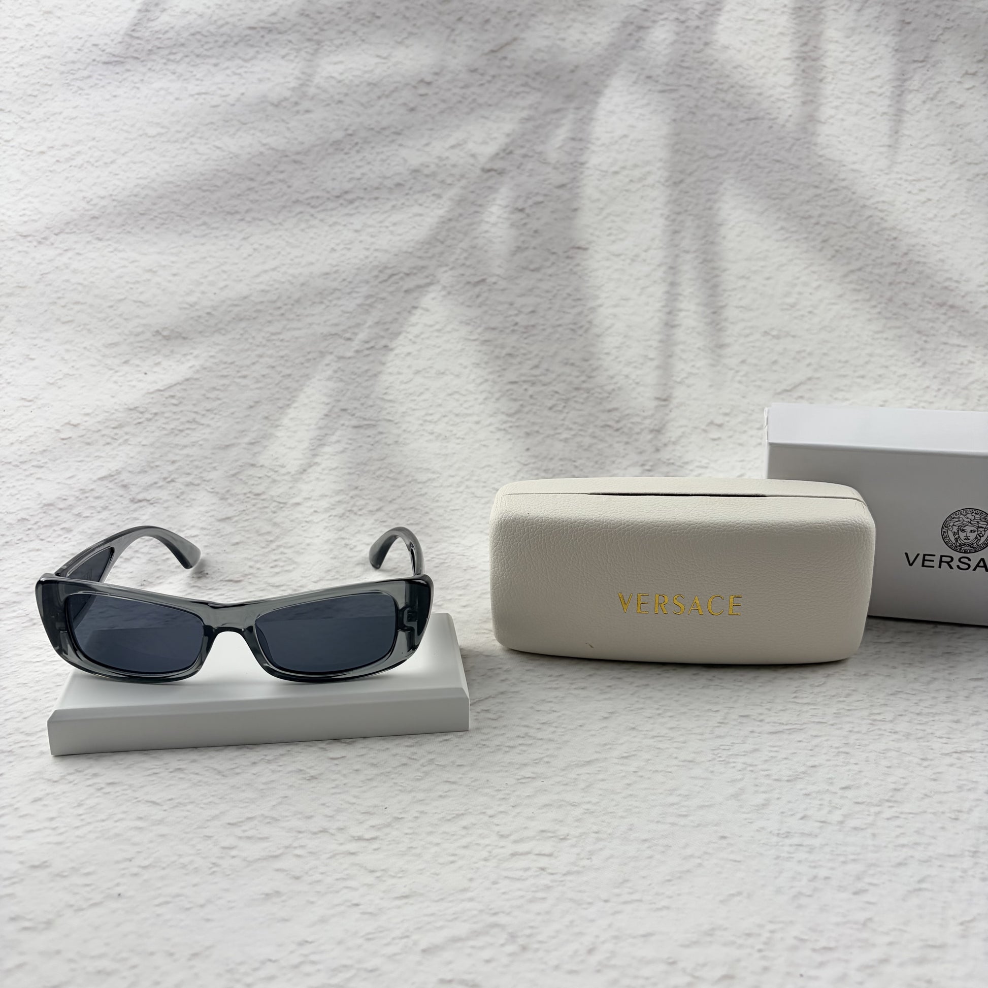 Modern rectangular sunglasses in translucent gray with dark tinted lenses, includes protective case.