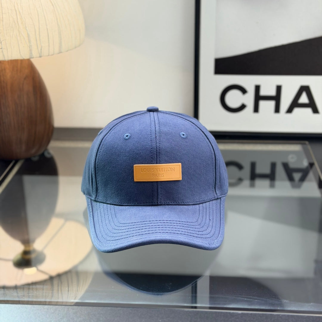 A navy blue cotton baseball cap with a rectangular tan leather-style patch on the front panel.