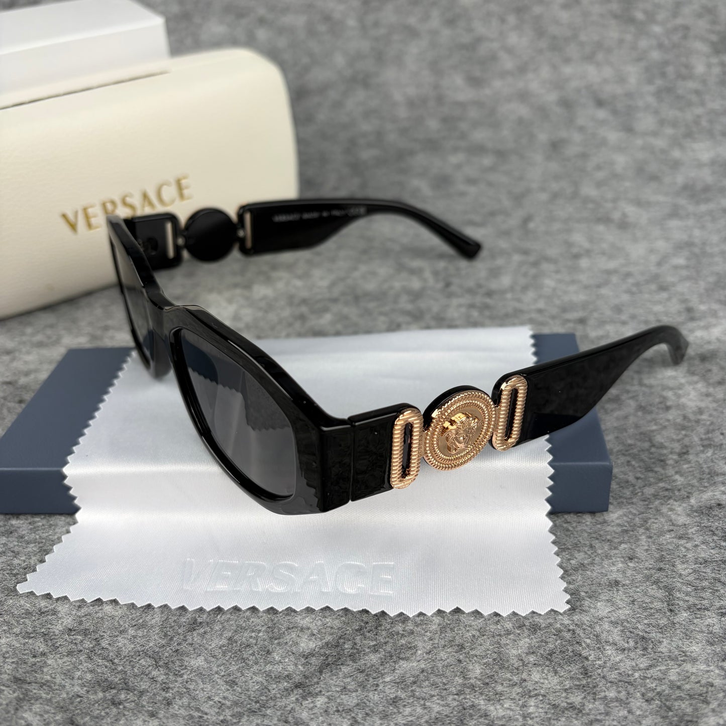 Classic black rectangular frame sunglasses featuring decorative gold-tone metallic side accents.