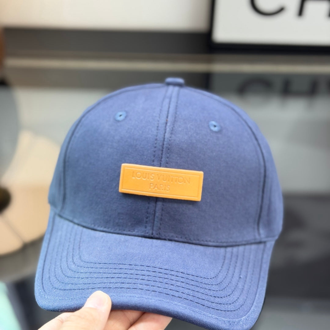 A navy blue cotton baseball cap with a rectangular tan leather-style patch on the front panel.
