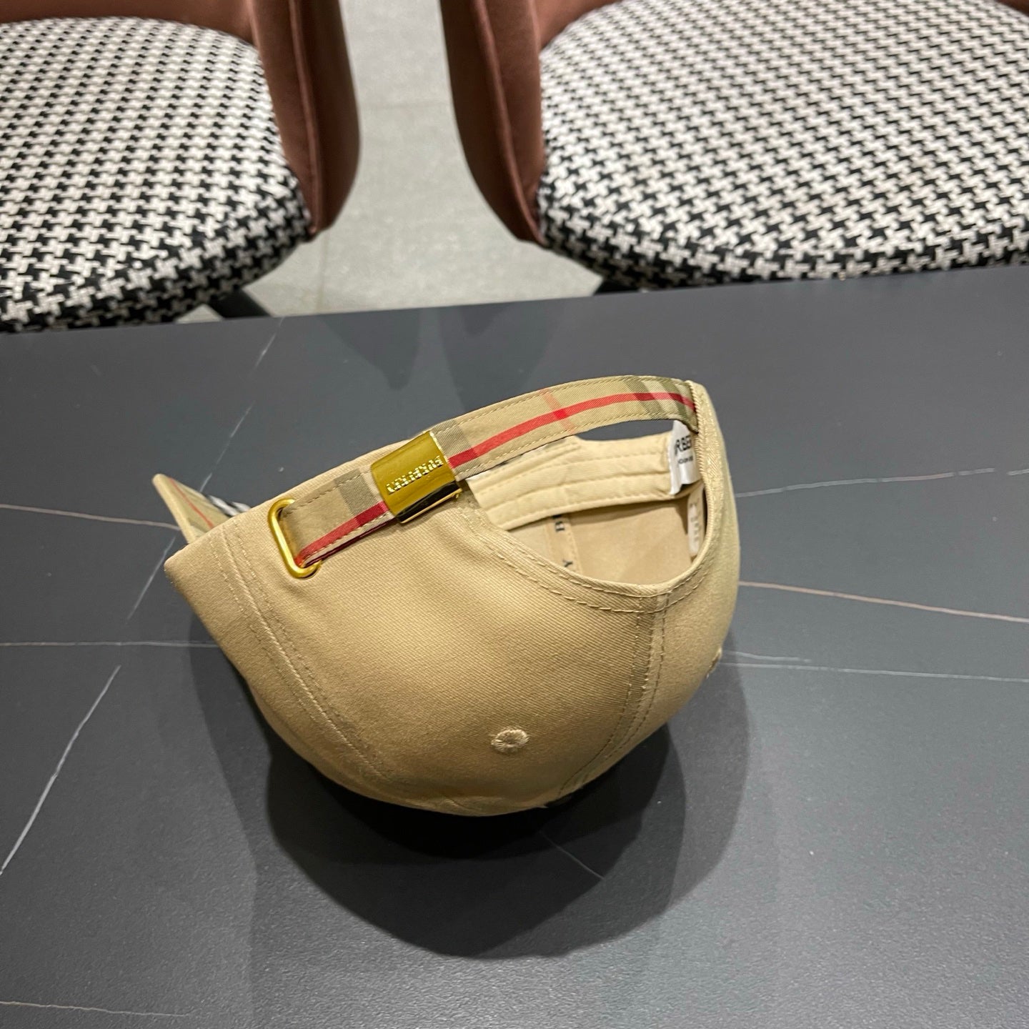 Khaki baseball cap with detailed embroidery on the front and an adjustable strap closure.