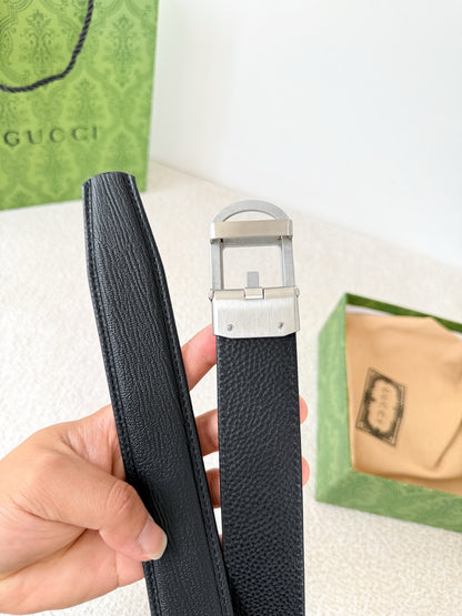 Premium black leather belt with a modern silver automatic steel buckle and detailed grain texture.