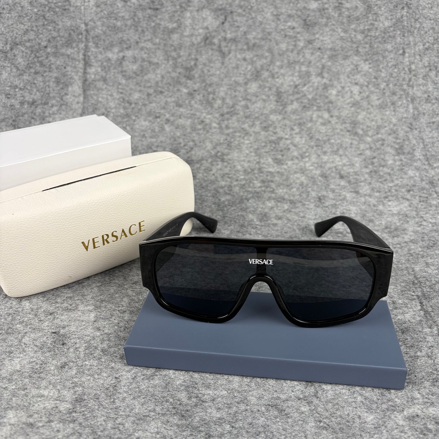 Oversized black shield sunglasses with a clean, modern aesthetic and protective hard storage case.