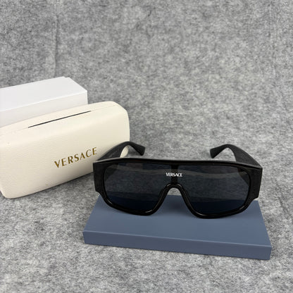 Oversized black shield sunglasses with a clean, modern aesthetic and protective hard storage case.