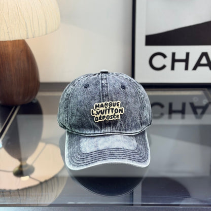 A grey distressed washed denim baseball cap with an embroidered patch on the front panel.