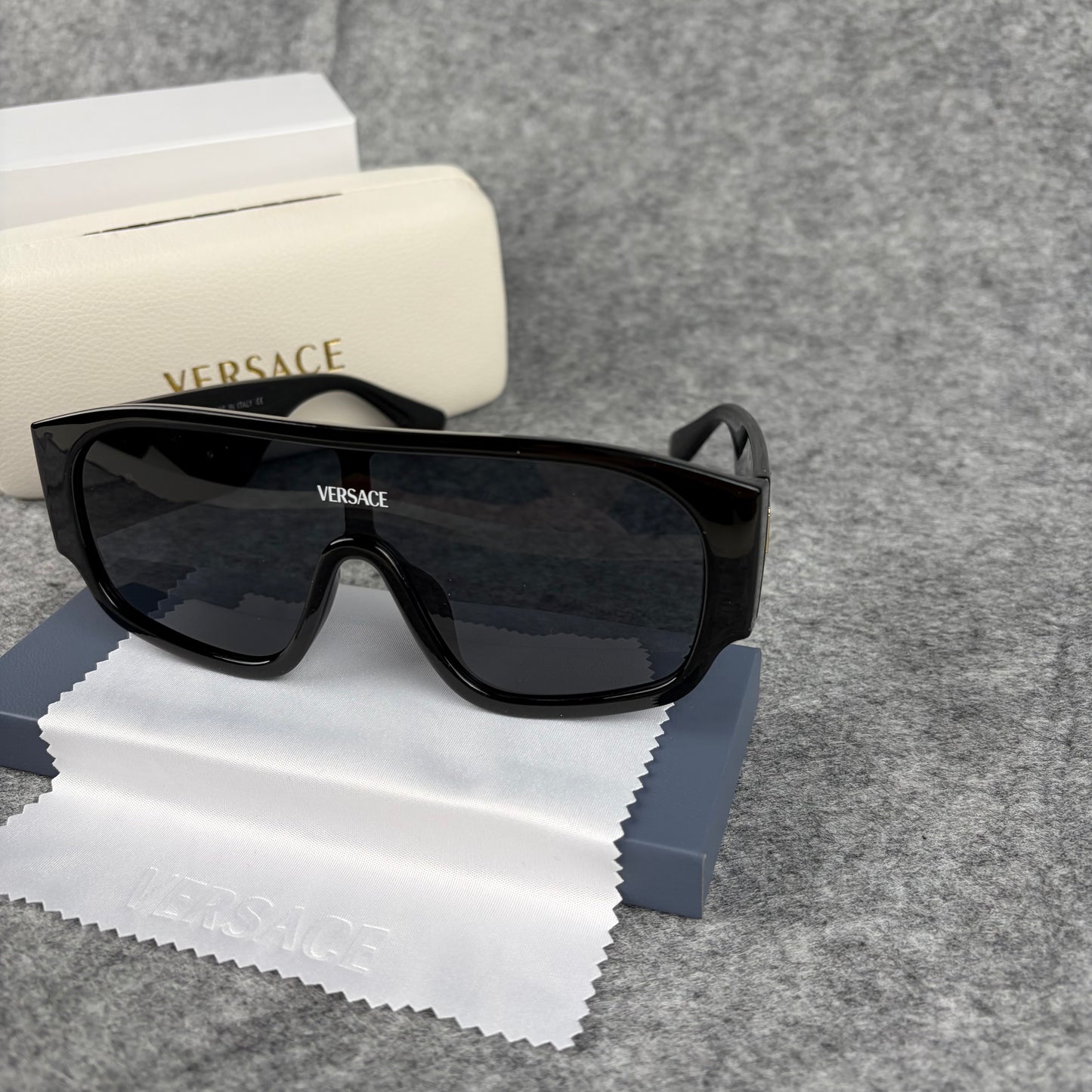 Oversized black shield sunglasses with a clean, modern aesthetic and protective hard storage case.