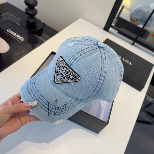 A light blue distressed denim baseball cap with a triangular embroidered patch on the front.