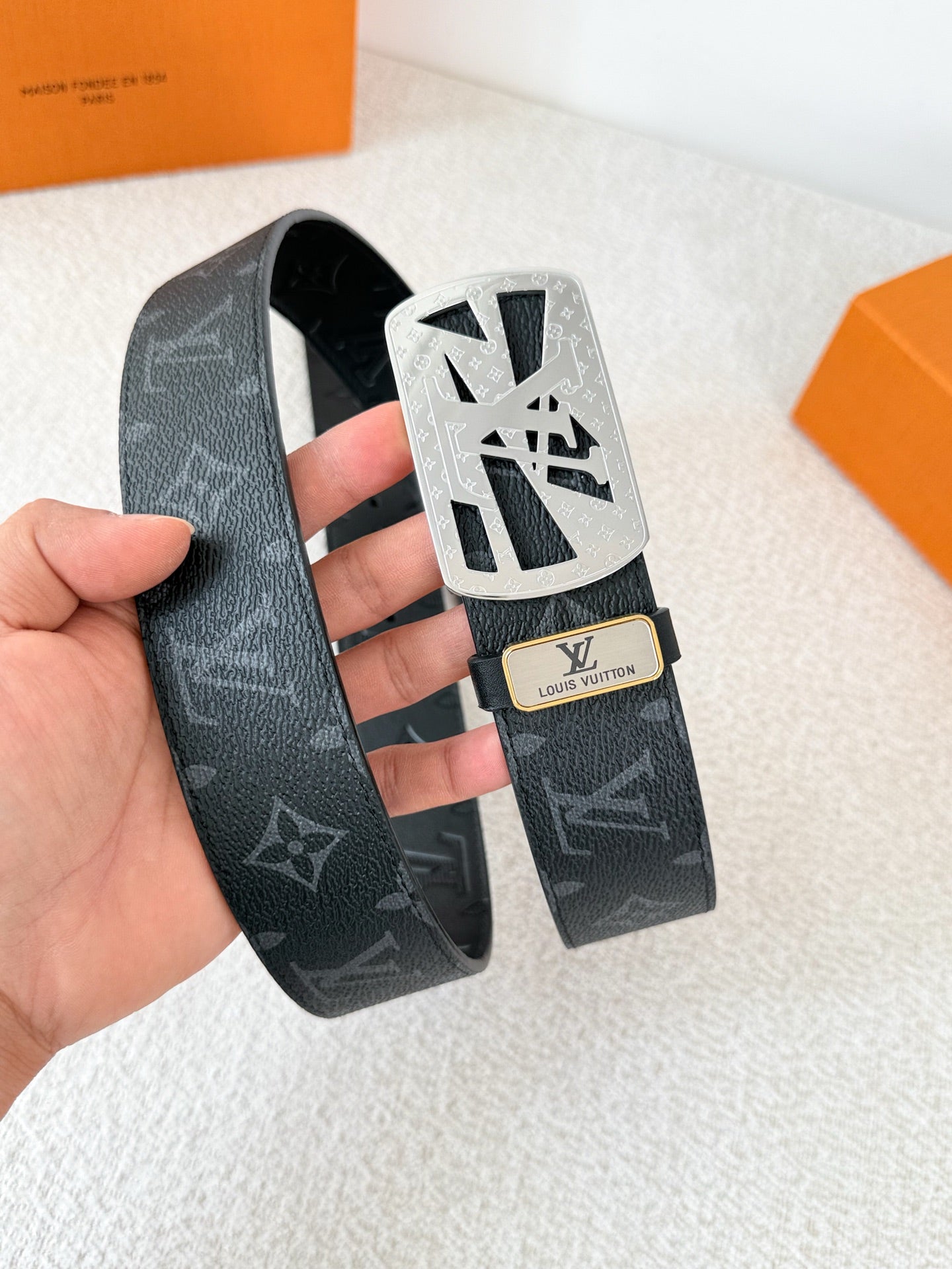 A black leather belt with monogram pattern and an intricate silver-tone buckle, 3.8cm wide.