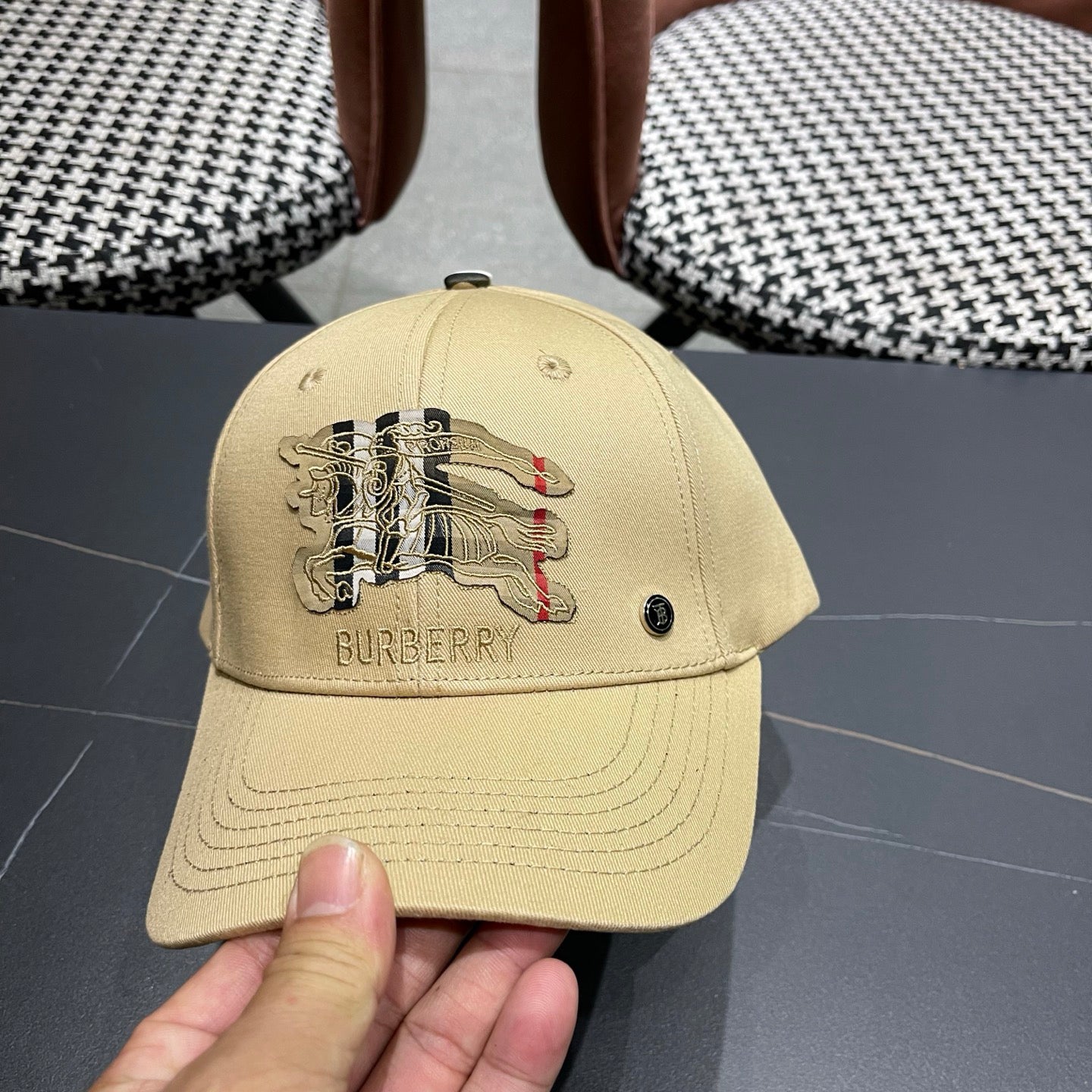Khaki baseball cap with detailed embroidery on the front and an adjustable strap closure.