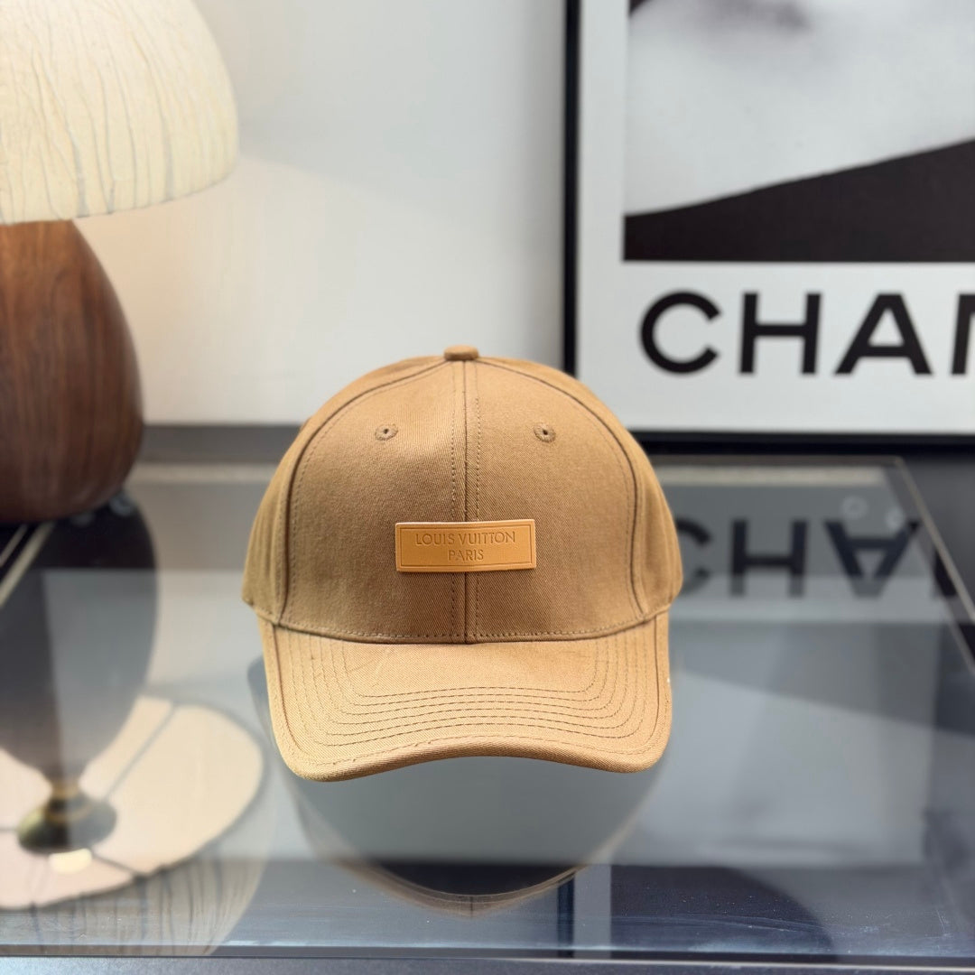 A premium camel-colored cotton baseball cap with a structured crown and an embossed leather patch.