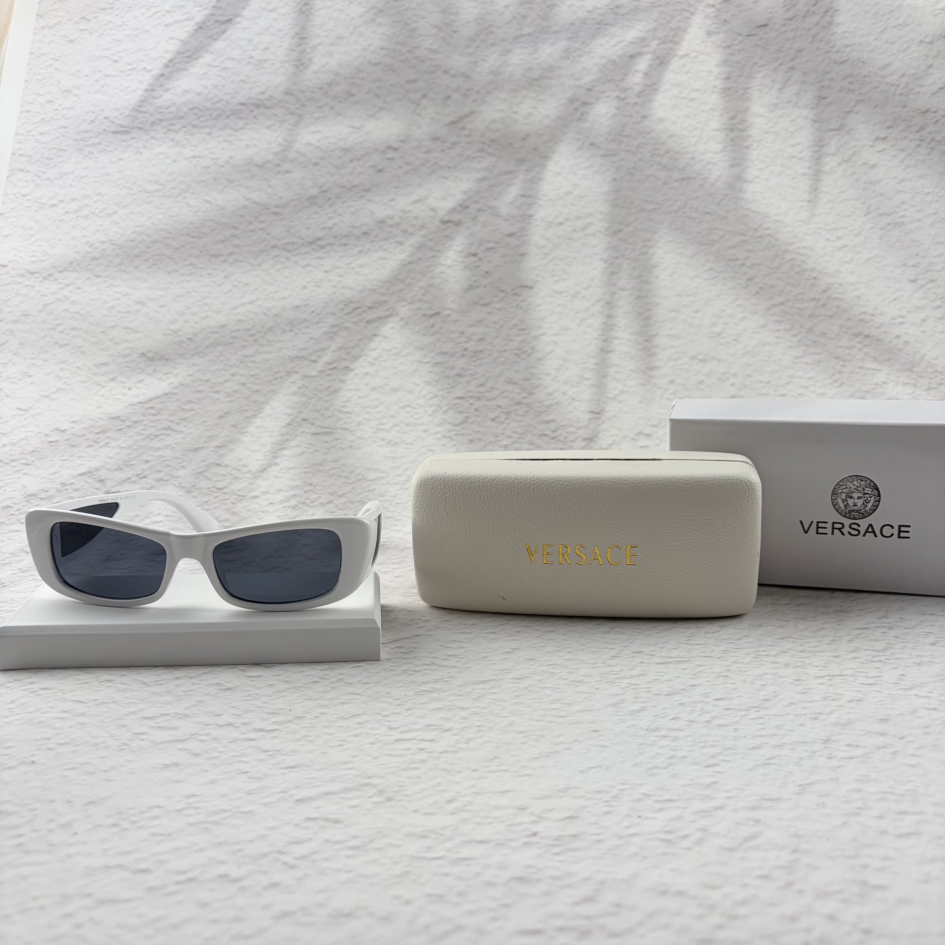 A pair of modern rectangular sunglasses with a bright white frame and dark tinted lenses.