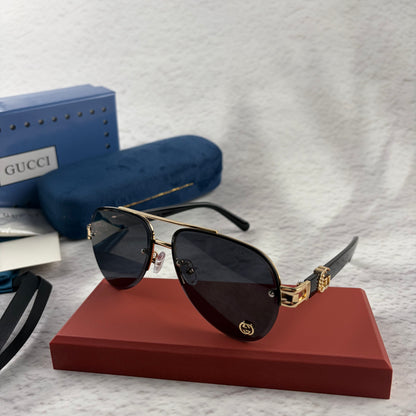 Pilot sunglasses with gold frame accents and dark lenses on a red display case.