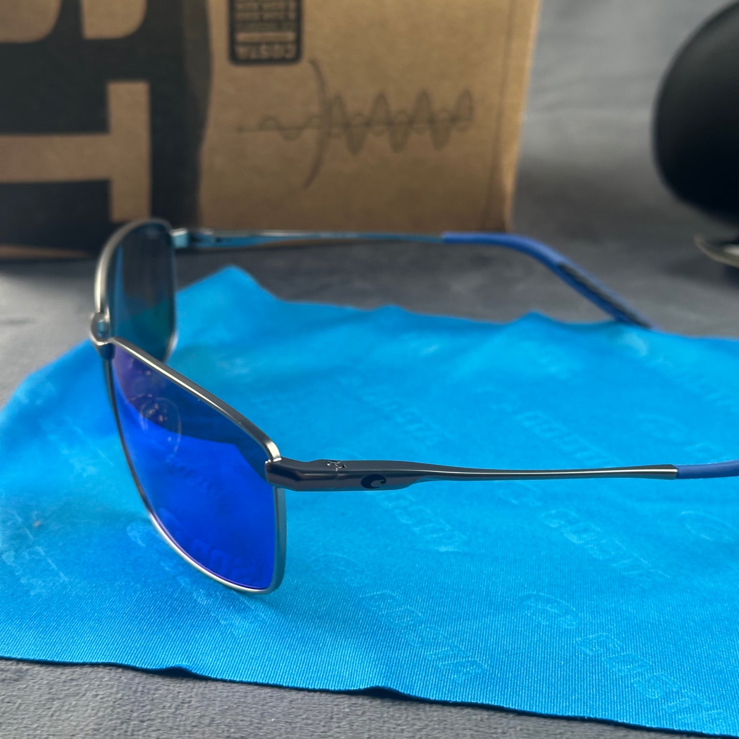 Close-up of performance polarized sunglasses with blue mirror lenses and lightweight metal frame.