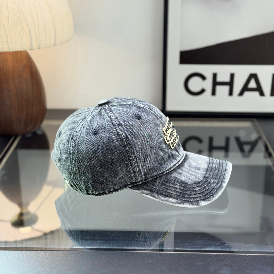 A grey distressed washed denim baseball cap with an embroidered patch on the front panel.
