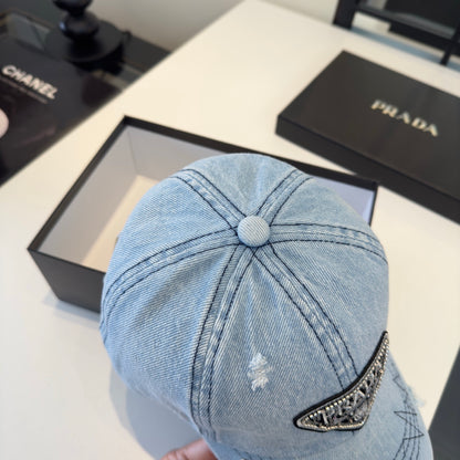 A light blue distressed denim baseball cap with a triangular embroidered patch on the front.