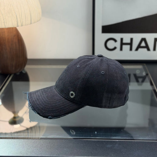 A black cotton baseball cap with a distressed brim and a small metallic circular side detail.