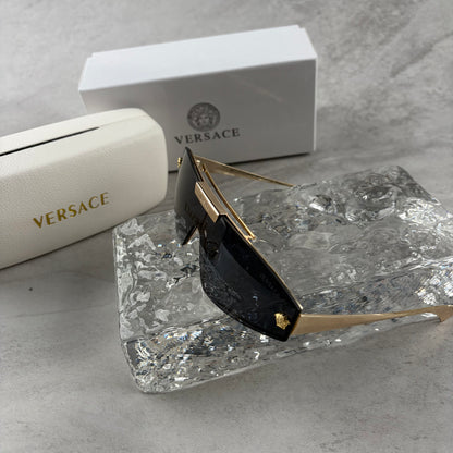 Gold metal frame shield sunglasses with dark lenses, featuring elegant temple detailing.