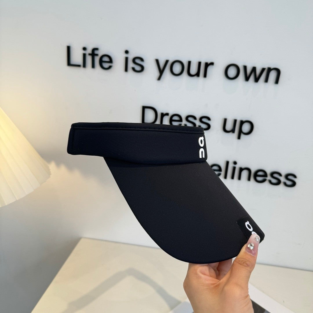 Close up of a black athletic sun visor with an adjustable strap, lightweight and breathable fabric.