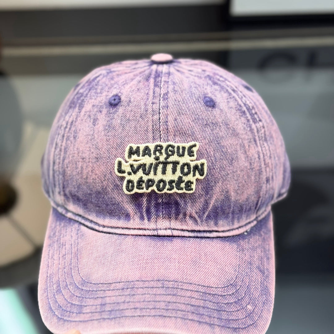 Distressed purple washed denim baseball cap with front embroidery patch, adjustable strap back.