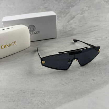 Modern shield sunglasses with a sleek black frame and dark tinted lenses on a grey background.