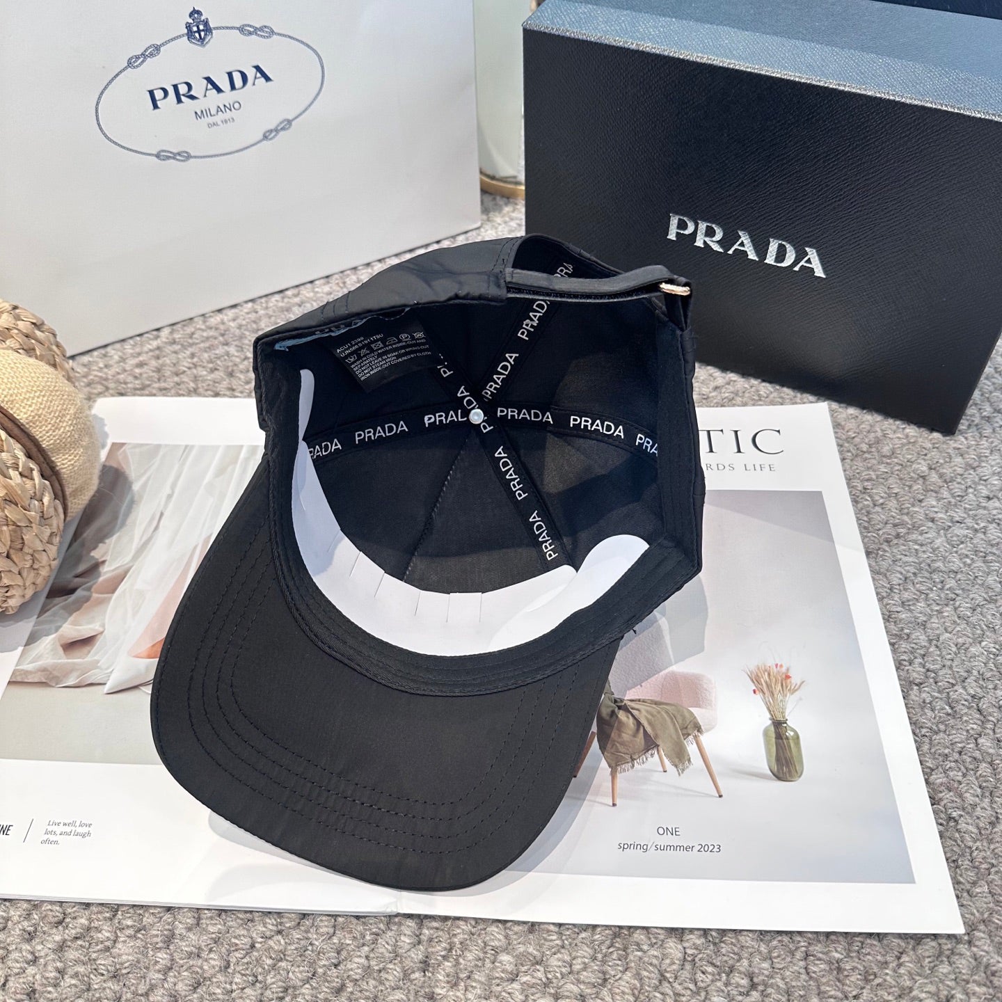 Black nylon baseball cap with white embroidered lettering and side metal logo plaque.