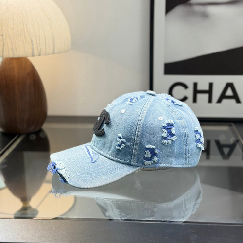 Distressed light wash denim baseball cap with frayed edges and embroidered front emblem.
