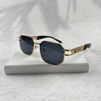 Gold tone metal frame geometric sunglasses with dark lenses on a white display block.