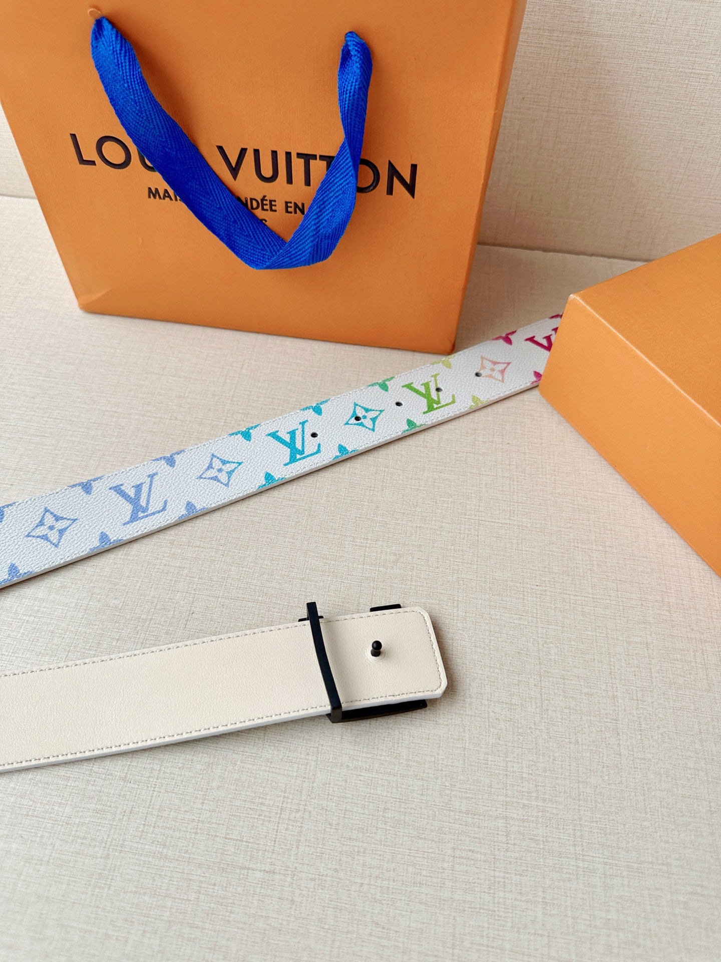 Multicolor monogram canvas belt with a black signature buckle and smooth leather backing.