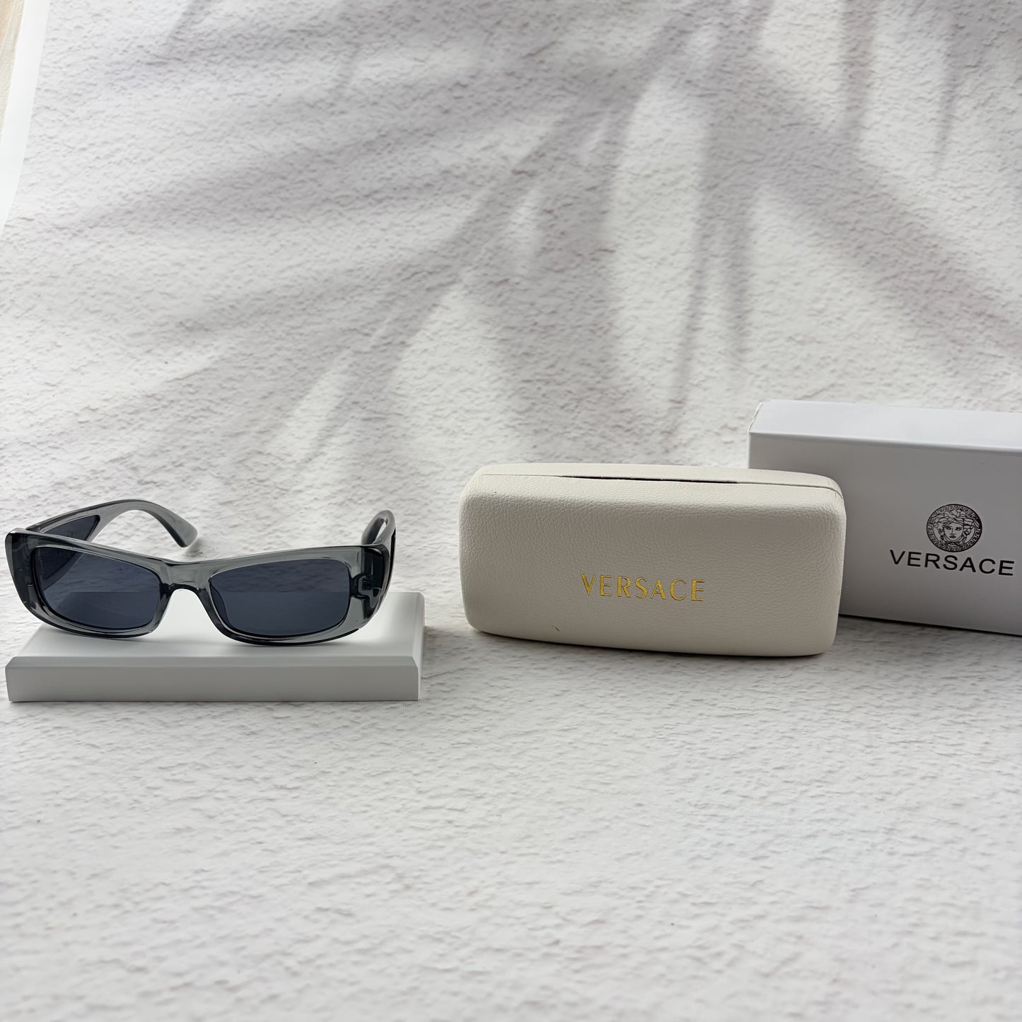 Modern rectangular sunglasses in translucent gray with dark tinted lenses, includes protective case.