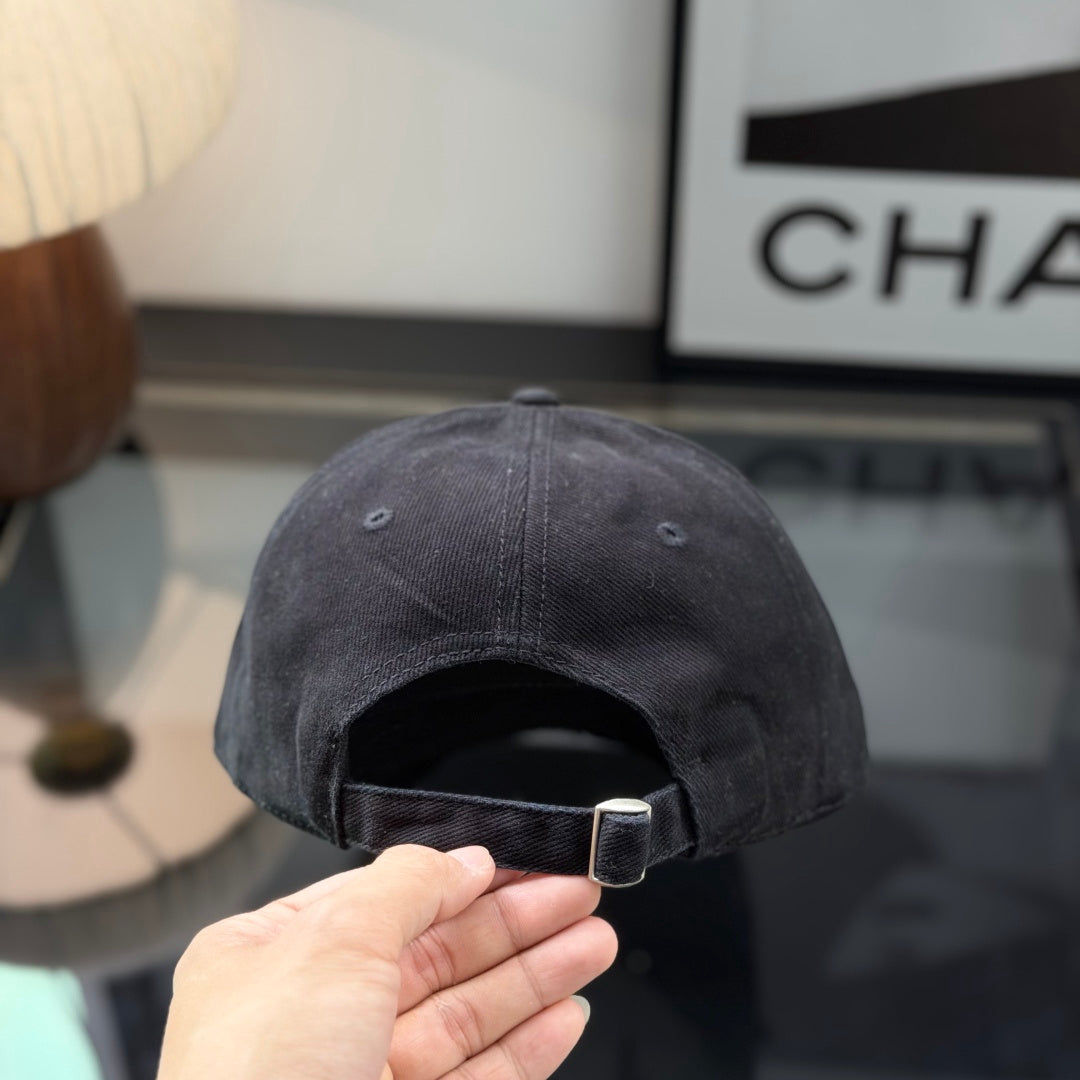 A black cotton baseball cap with a distressed brim and a small metallic circular side detail.