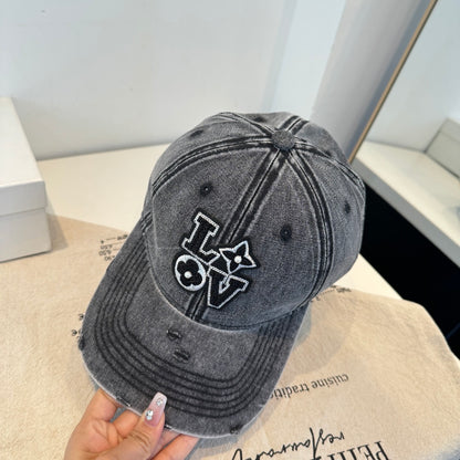 Distressed charcoal denim baseball cap with an embroidered LOVE patch featuring flower accents.