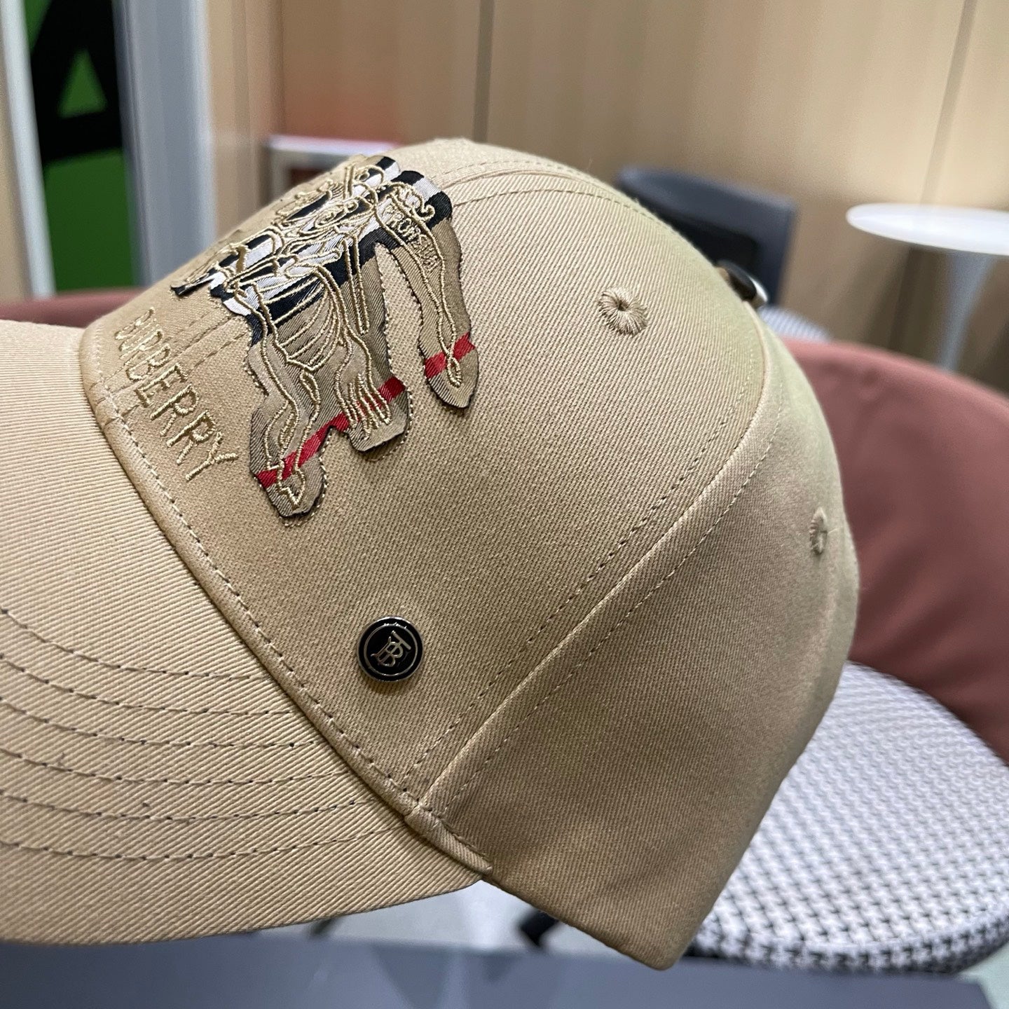 Khaki baseball cap with detailed embroidery on the front and an adjustable strap closure.