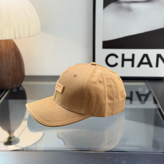 A premium camel-colored cotton baseball cap with a structured crown and an embossed leather patch.