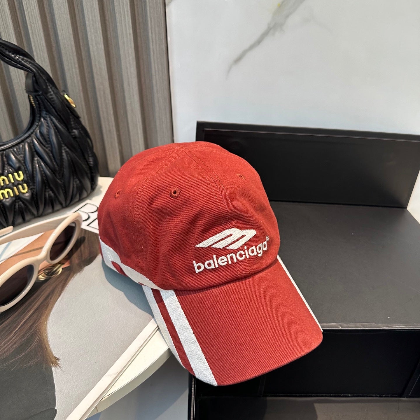A vibrant red baseball cap featuring bold white side stripes and centered white embroidery.