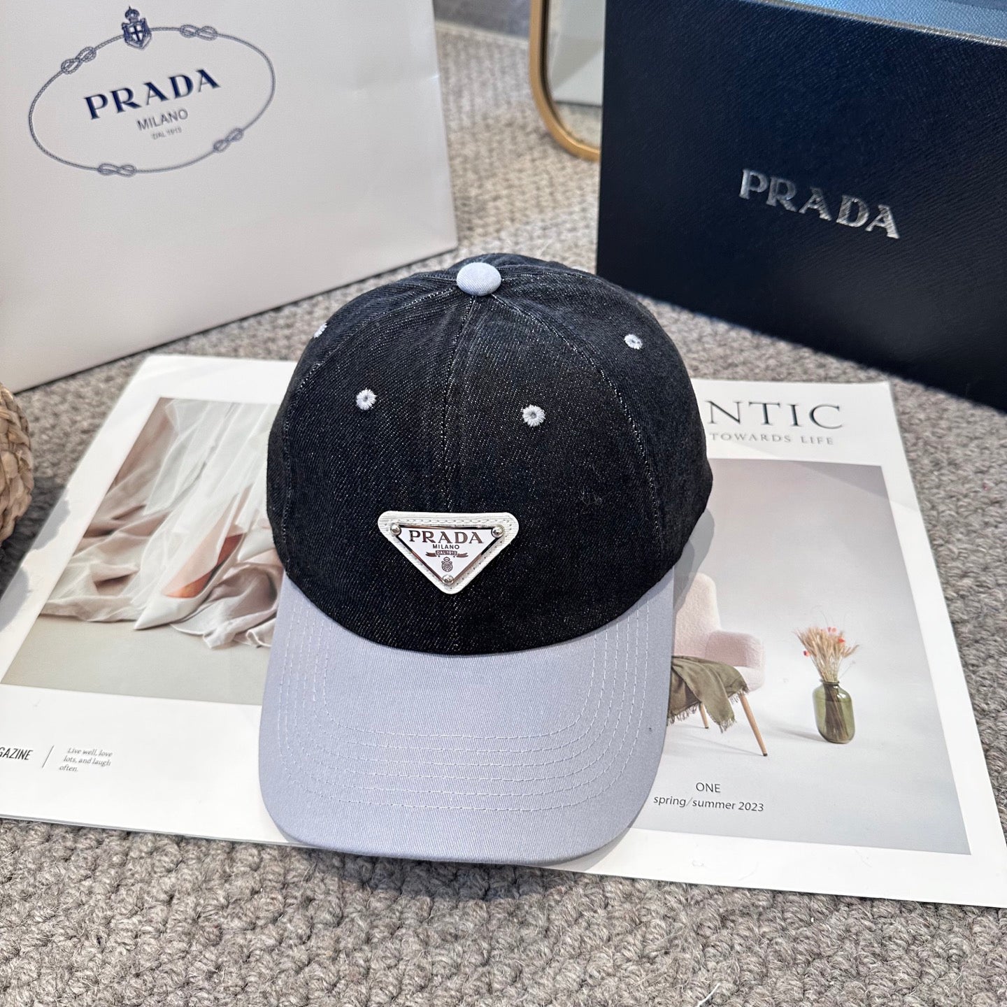A two-tone denim baseball cap featuring a white triangle emblem patch on the front, neutral brim.