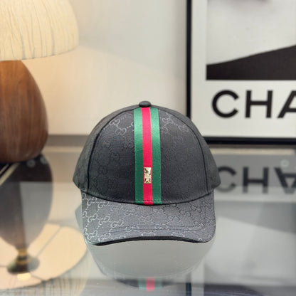 Close-up of a premium black baseball cap with a red and green center stripe and monogram pattern.