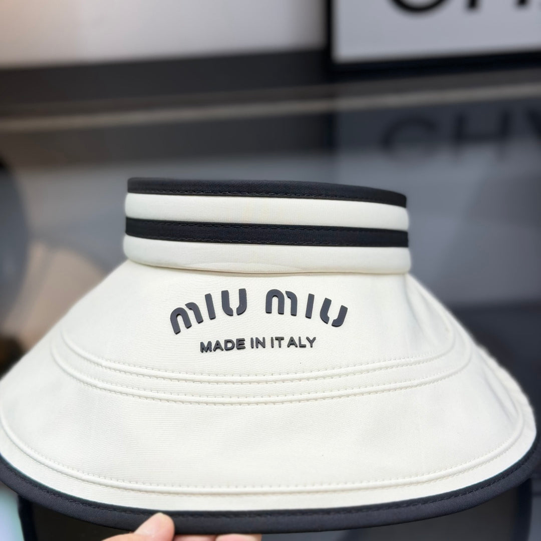 A stylish off-white open-top sports visor with black trim and embroidered text detailing.