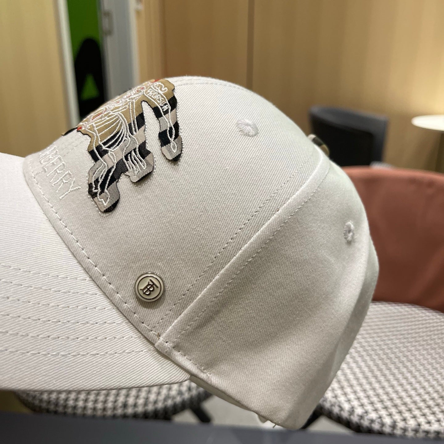 A white structured cotton baseball cap featuring an intricate equestrian embroidery patch on front.